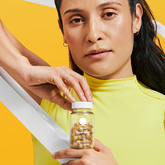 Model holding a bottle of Stress Relief in front of them