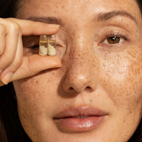 Woman holding a bottle of Ritual's Women Multivitamin 18+